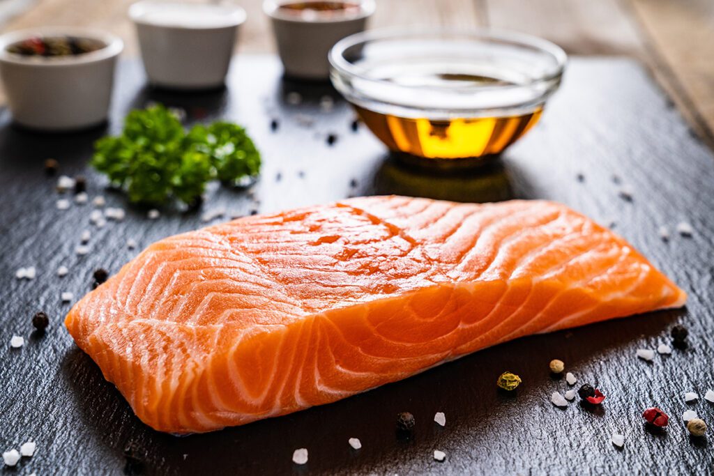 Fresh raw salmon fillet on black stone cutting board