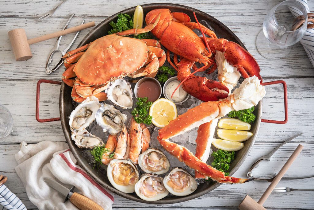 Pot with cooked lobster, crab legs, oysters and shrimp